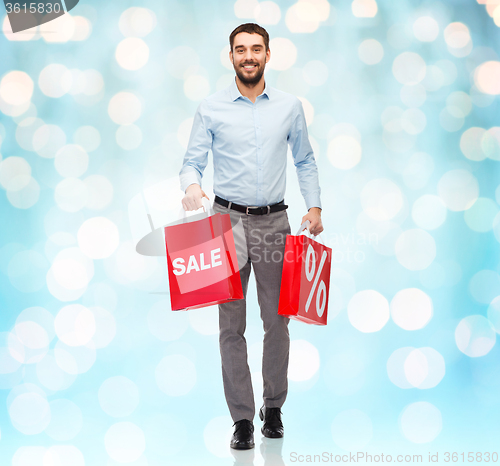 Image of smiling man with red shopping bag