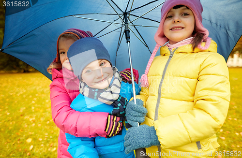 Image of happy children with umbrella in autumn park