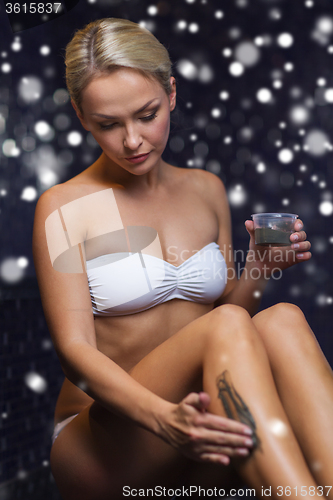 Image of woman applying therapeutic mud in spa or sauna