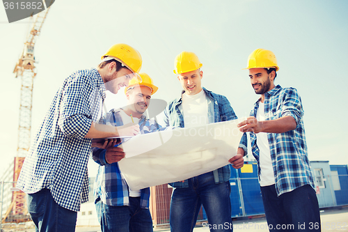 Image of group of builders with tablet pc and blueprint