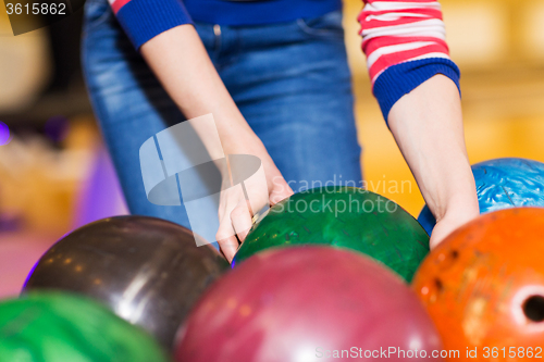 Image of close up of woman hands choosing bowling ball