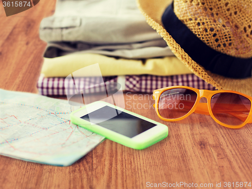 Image of close up of summer clothes and travel map on floor