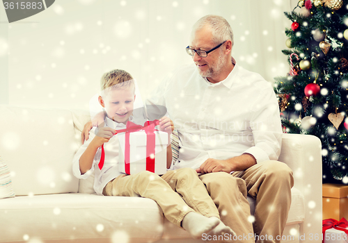 Image of smiling grandfather and grandson with gift box