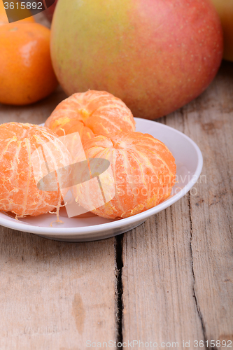 Image of Bowls of slices mandarin with apple on rustic wooden background