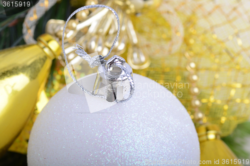 Image of festive golden christmas decoration, candles, white balls, green fir tree branch, close up