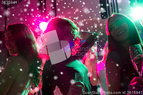 Image of smiling friends with glasses of champagne in club