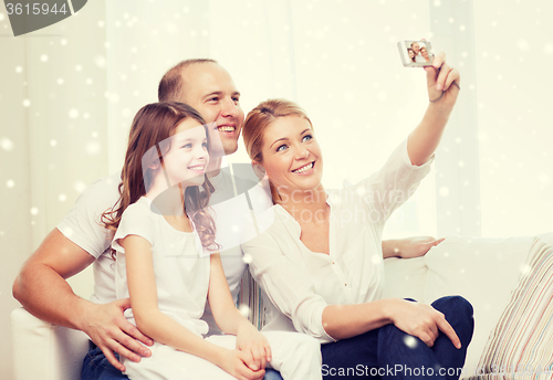 Image of happy family with camera taking picture at home