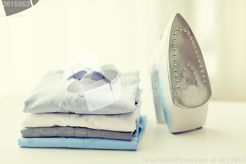 Image of close up of iron and clothes on table at home