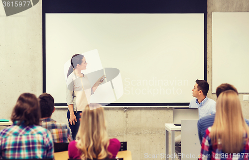 Image of group of students and smiling teacher in classroom