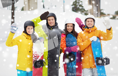 Image of happy friends in helmets with snowboards