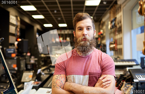 Image of assistant or customer with beard at music store