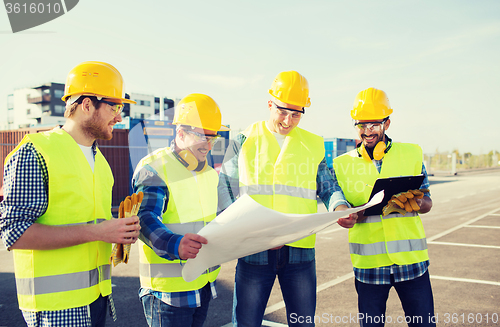 Image of group of builders with tablet pc and blueprint