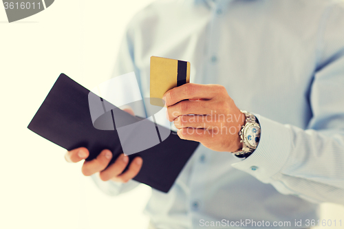 Image of close up of man holding wallet and credit card