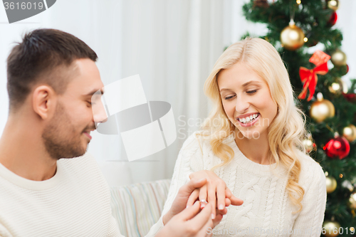 Image of man giving woman engagement ring for christmas