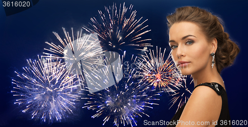 Image of beautiful woman wearing earrings over firework