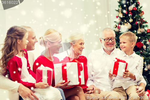 Image of smiling family with gifts at home