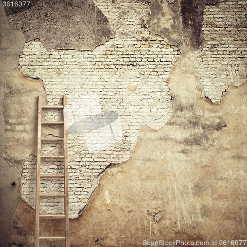 Image of weathered stucco wall with wooden ladder