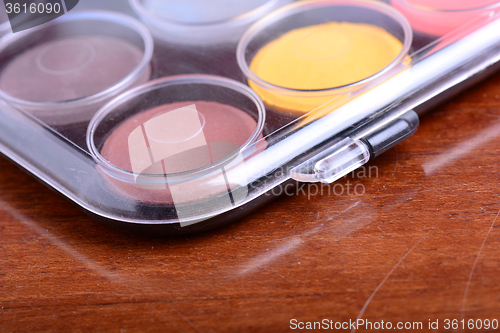 Image of Watercolor paints set on wooden background