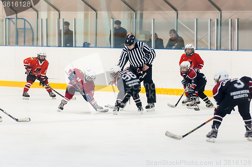 Image of Puck playing between players of ice-hockey teams