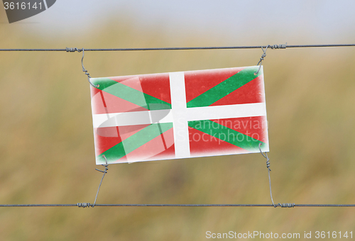 Image of Border fence - Old plastic sign with a flag