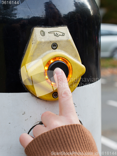 Image of Hand pushing button for traffic light