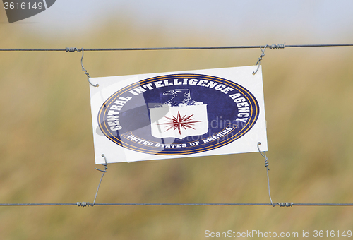 Image of Border fence - Old plastic sign with a flag