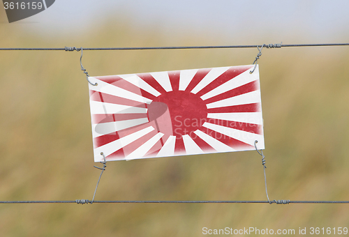 Image of Border fence - Old plastic sign with a flag