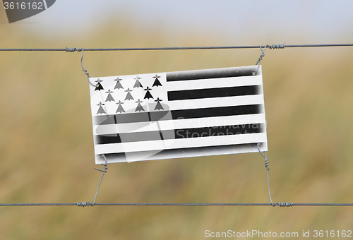 Image of Border fence - Old plastic sign with a flag