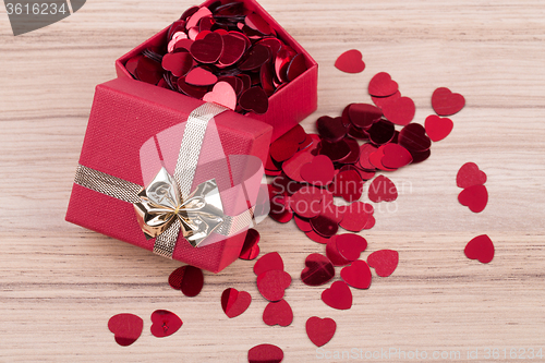 Image of Red hearts confetti on wooden background