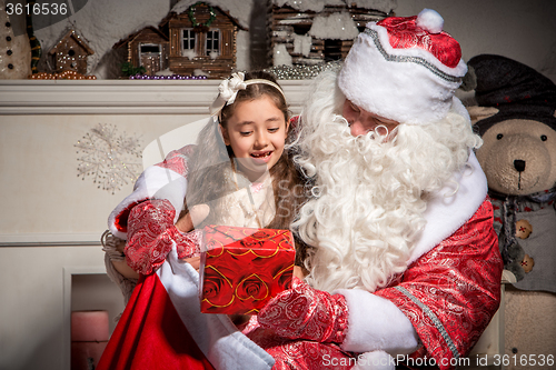 Image of holidays and people concept - smiling little girl with santa claus 