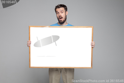 Image of The surprised man showing empty white billboard or banner 