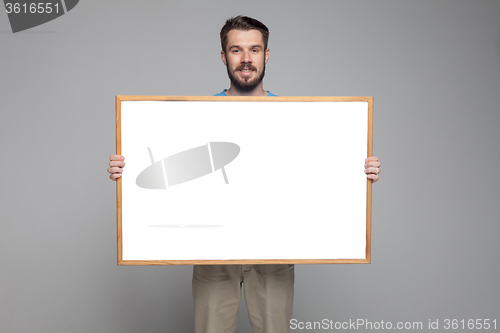 Image of The smiling man showing empty white billboard or banner 