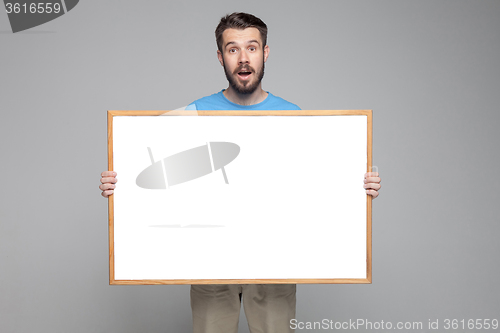 Image of The surprised man showing empty white billboard or banner 