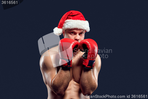 Image of Christmas fitness boxer wearing santa hat boxing on black background