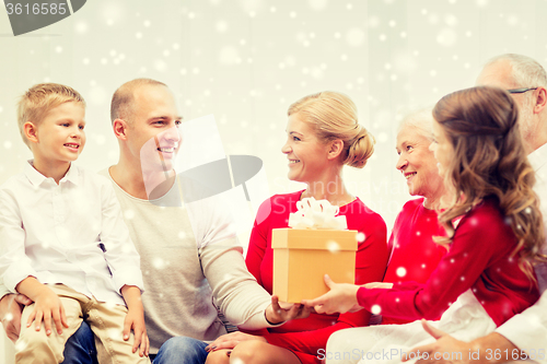 Image of smiling family with gifts at home