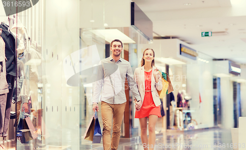 Image of happy young couple with shopping bags in mall