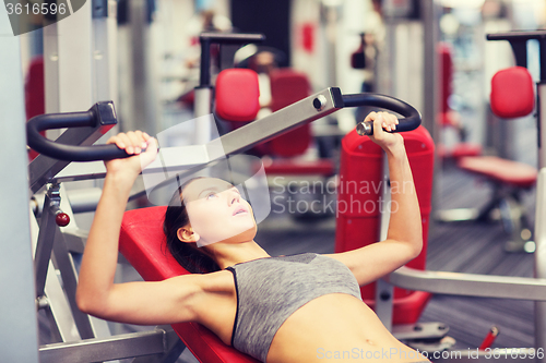 Image of young woman exercising on gym machine