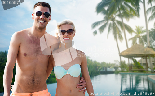 Image of happy couple in swimwear hugging over hotel resort