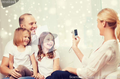 Image of happy family with camera taking picture at home