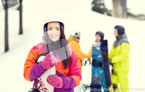 Image of happy friends in helmets with snowboards