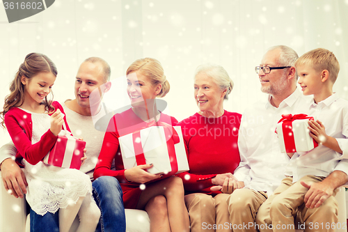 Image of smiling family with gifts at home