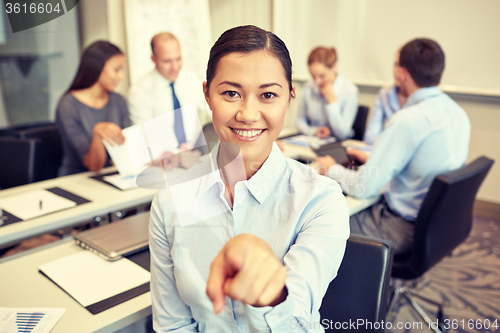 Image of group of smiling businesspeople meeting in office