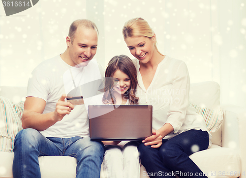 Image of happy family with laptop computer and credit card