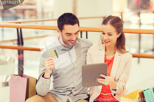 Image of couple with tablet pc and credit card in mall
