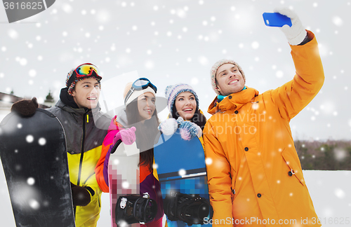 Image of happy friends with snowboards and smartphone