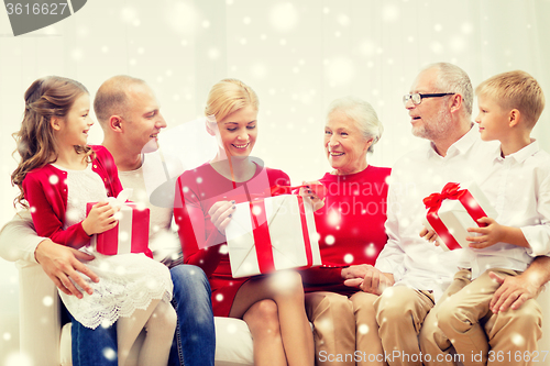 Image of smiling family with gifts at home