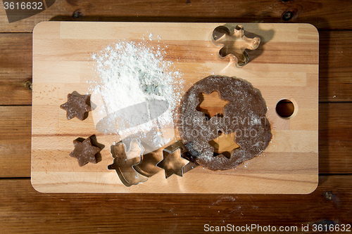 Image of close up of ginger dough, molds and flour on board