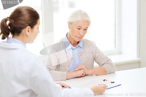 Image of doctor with clipboard and senior woman at hospital