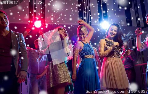 Image of smiling friends dancing in club