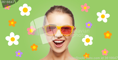 Image of happy teenage hippy girl in shades with flowers